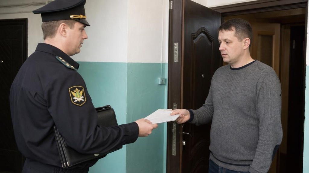 Судебный пристав вручает уведомление должнику