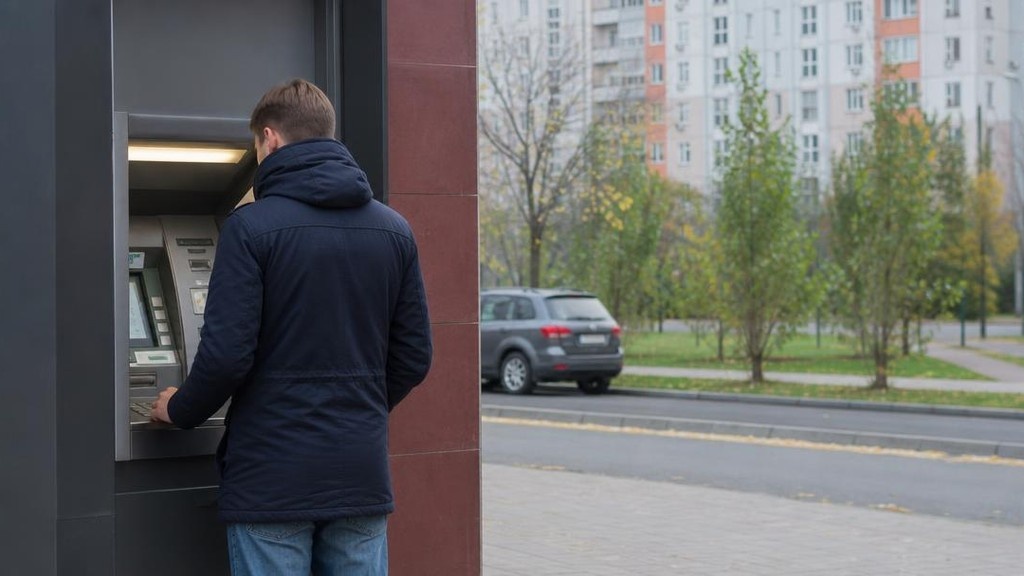 человек у банкомата в жилом районе города