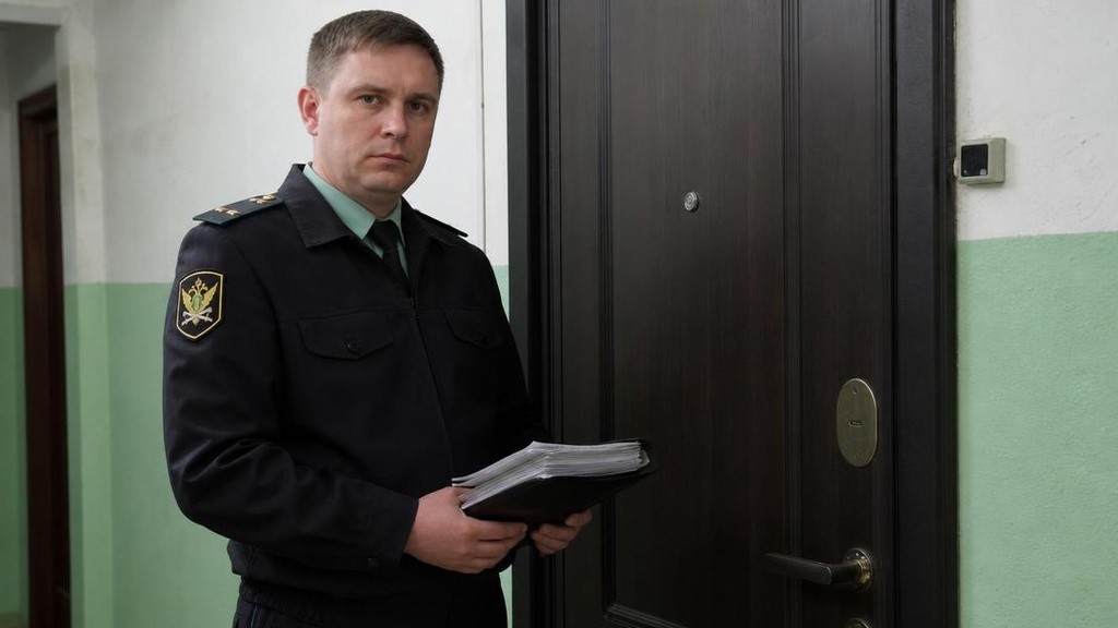 судебный пристав у двери квартиры с исполнительными документами